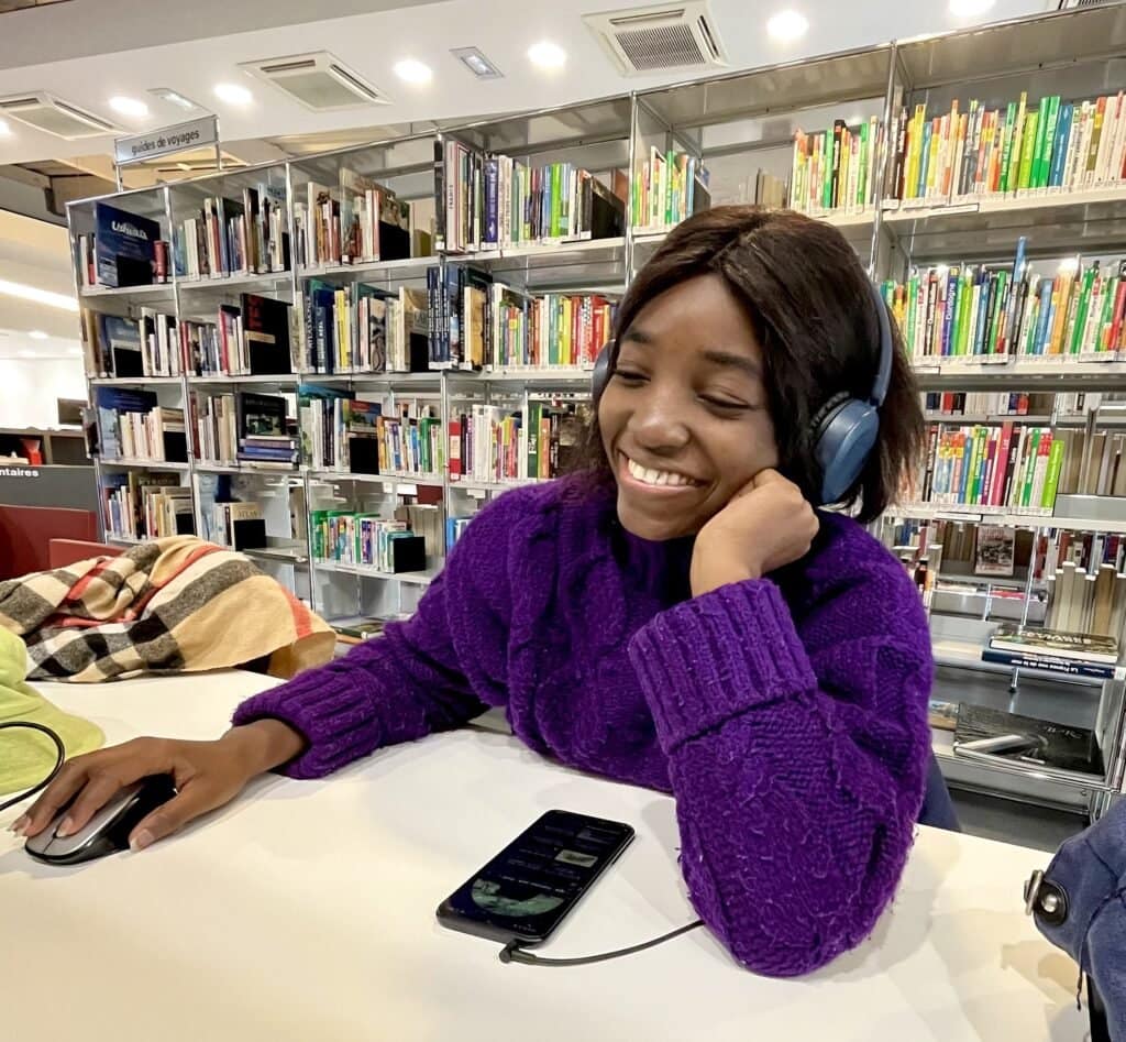 L'artiste visuelle et autrice lyna B dans une bibliothèque.