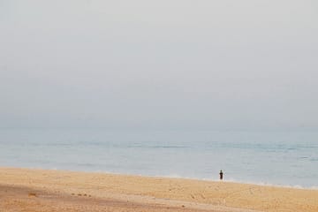 "Personne seule sur une plage, symbole de paix intérieure et recentrage spirituel"